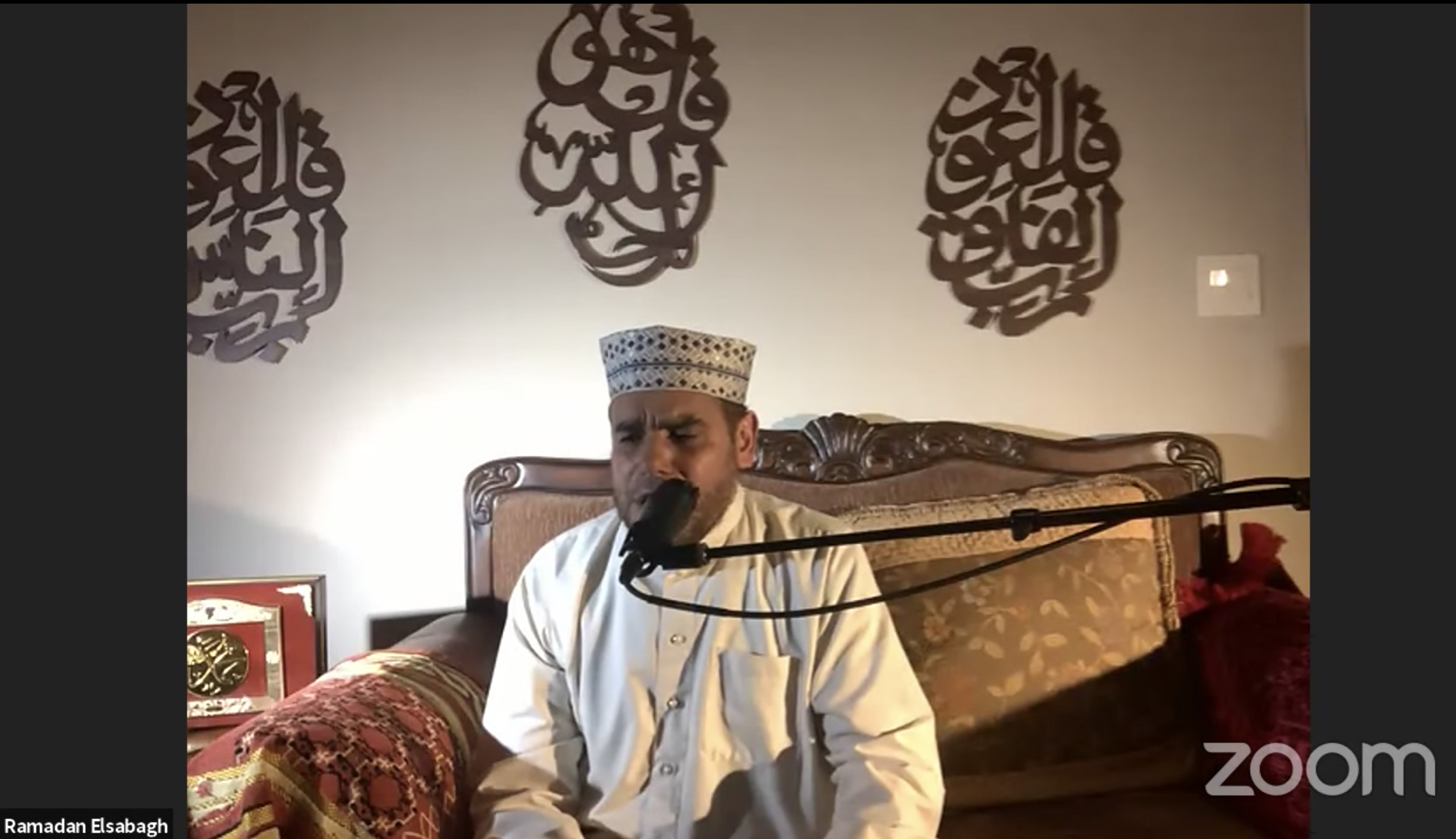 An Imam recites Qur'an while sitting down.