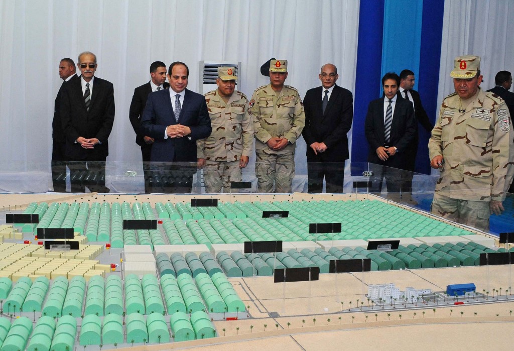 Egyptian President Abdel Fattah al-Sisi (2nd-L) looking at model diagrams of greenhouses during the inauguration of an agricultural project at Mohamed Naguib military base in al-Hammam region