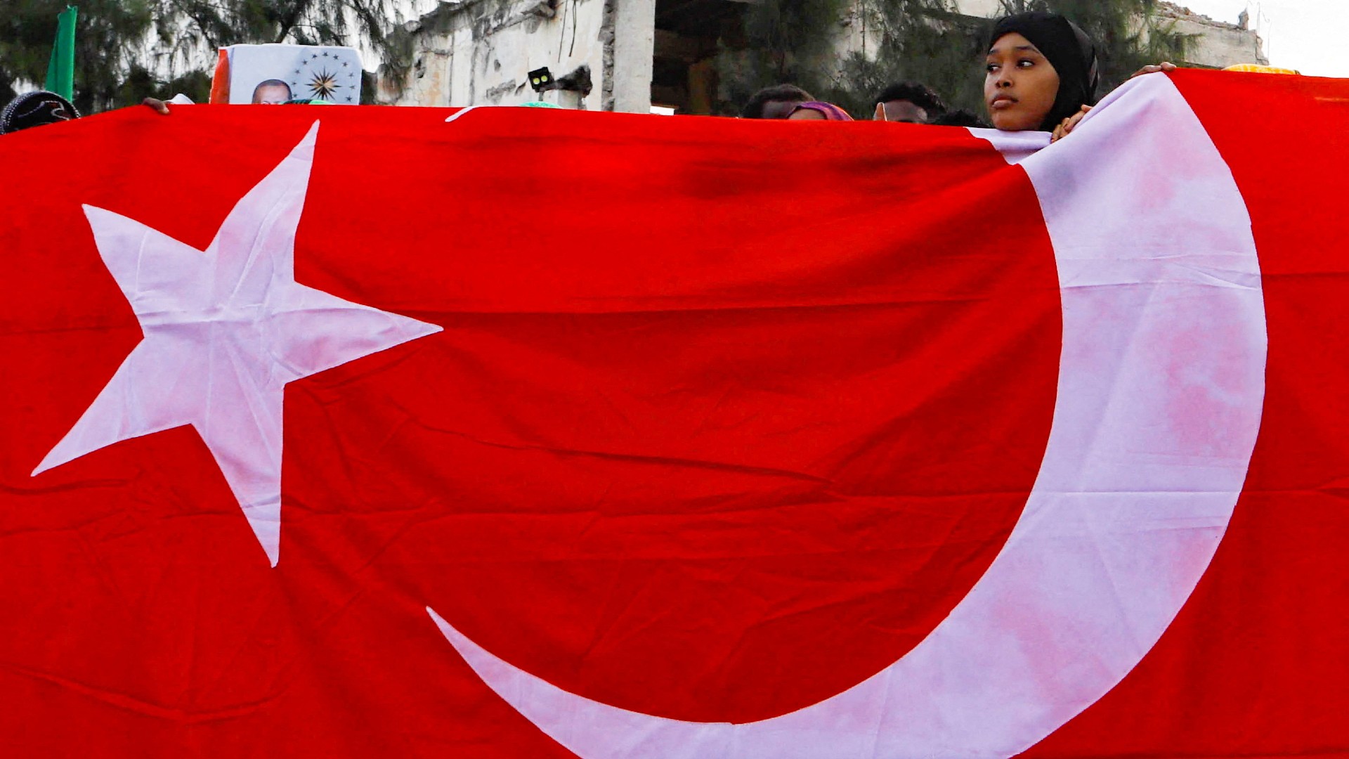 Somali supporters of Recep Tayyip Erdogan hold Turkey's flag during celebrations after the presidential election, in Mogadishu 29 May 2023 (Reuters/Feisal Omar)