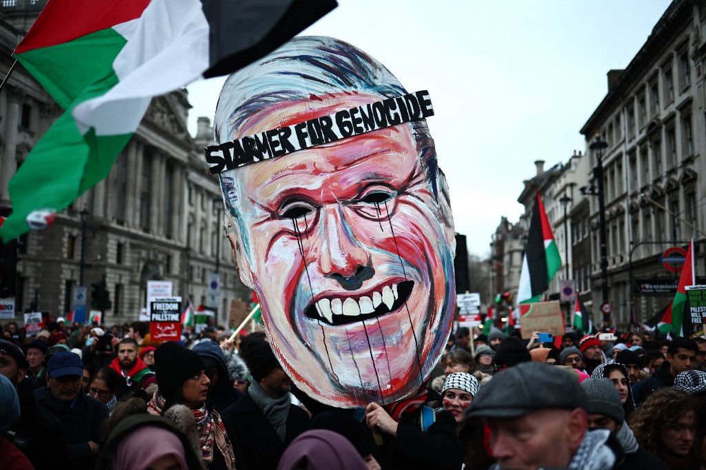 Pro-Palestinian activists and supporters carry a giant mask of Britain's main opposition Labour Party leader, Keir Starmer during a National March for Palestine in central London on January 13, 2024.