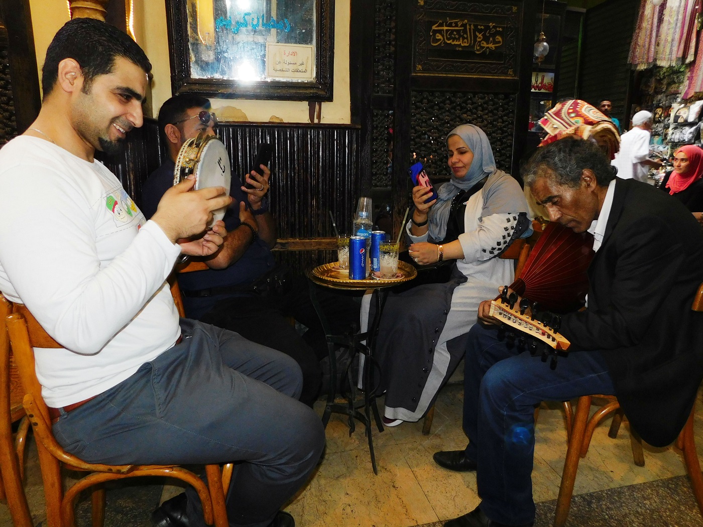 Des artistes de rue reprennent des chansons de la légendaire chanteuse égyptienne Oum Kalthoum pour un couple assis au café Fishawy (MEE)