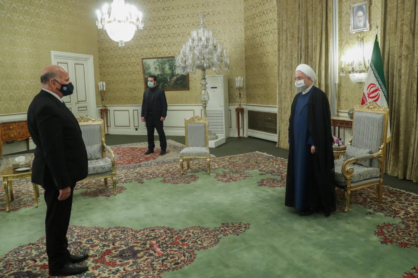 Hassan Rouhani (R) welcomes Iraqi Foreign Minister Fouad Hussein (L) 