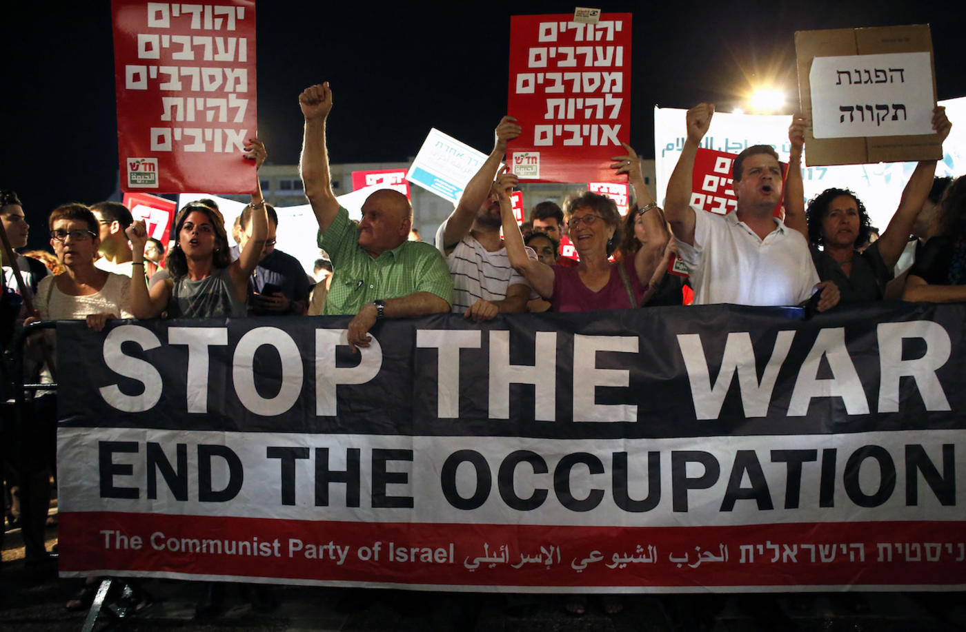 Israeli Communist Party supporters hold a "stop the war" banner as thousands of them gather at the Rabin Square in Tel Aviv on 62 July 2014 (AFP)