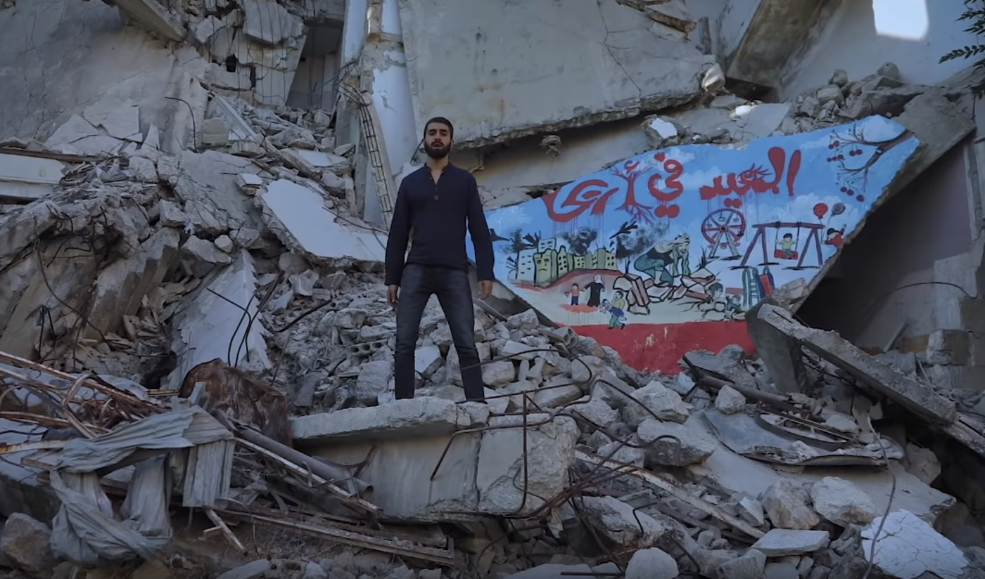 Amir in music video near rubble