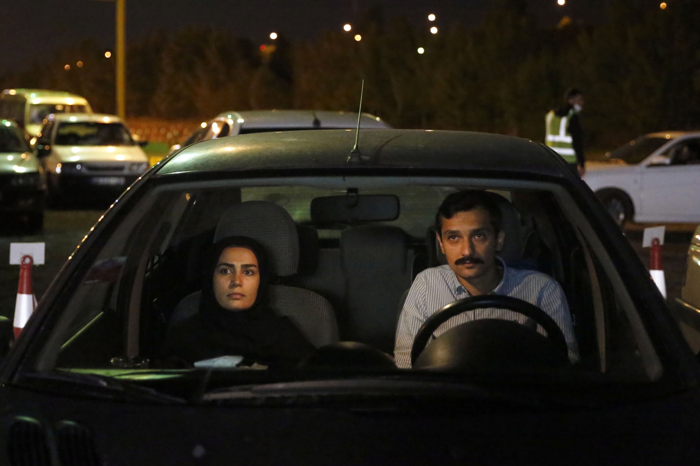 Iranians sitting in their vehicles attend a drive-in religious ceremony