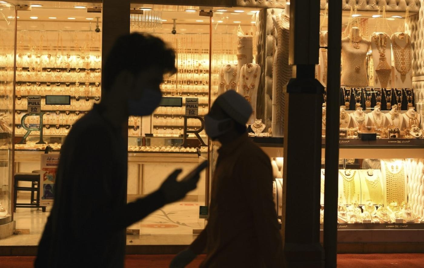 Des acheteurs passent devant une bijouterie dans le souk de l’or de Dubaï, en mai 2020 (AFP)