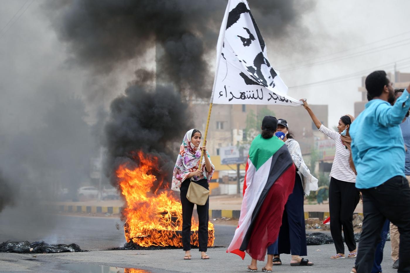 Une Soudanaise brandit un drapeau « Gloire aux martyrs » pendant une manifestation à Khartoum, le 23 mai 2020, pour commémorer le premier anniversaire du massacre du 3 juin (AFP)