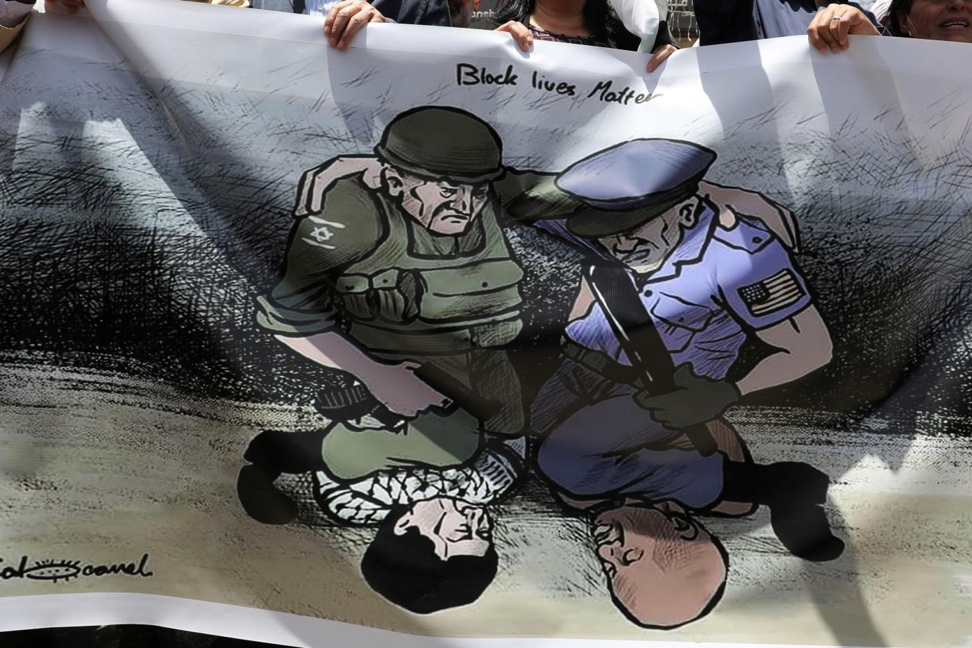 Des Palestiniens manifestent contre les violences policières et en soutien aux manifestants américains après la mort de George Floyd, dans la ville de Ramallah, en Cisjordanie occupée, le 8 juin (AFP)