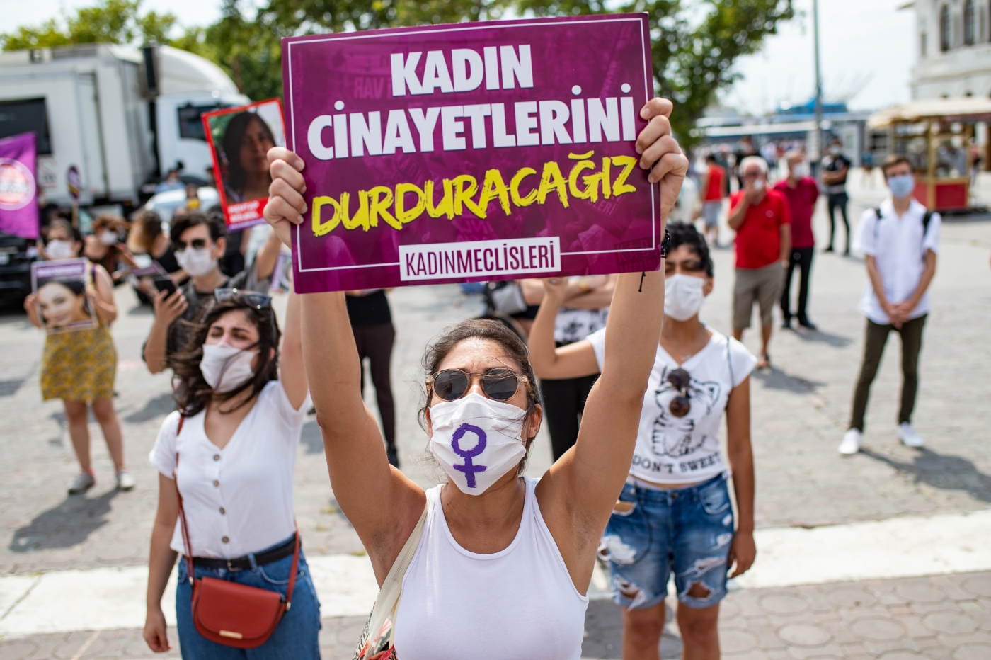 A demonstrator wearing a protective face mask, holds a placard reading 'stop femicides' during a protest called by KCDP (We Will Stop Femicides Platform - Kadin Cinayetlerini Durduracagiz Platformu) and Women’s Assemblies, for a better implementation of the Istanbul Convention and the Turkish Law 6284 for protection of the family and prevention of violence against women, in Istanbul, Turkey (AFP)