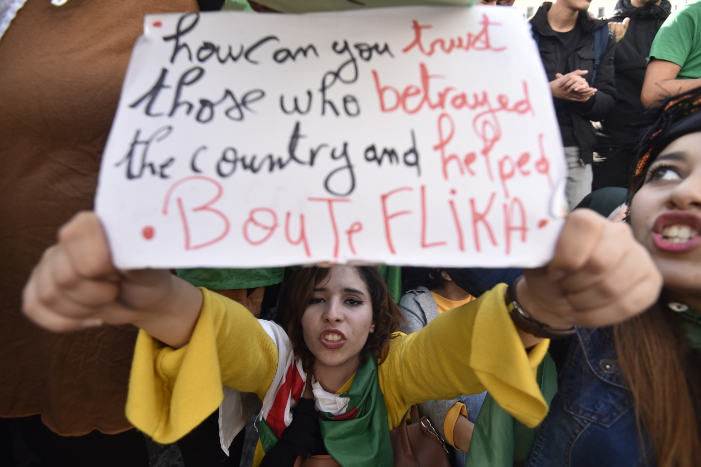 A protester holds up a placard during an anti-government demonstration in Algiers in 11 December 2019 (AFP)