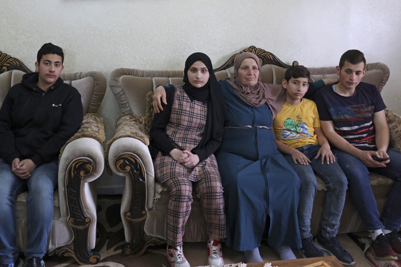 Houria Sabateen, dont la fille a été abattue par un soldat israélien le 10 avril, auprès de ses petits-enfants près de Bethléem en Cisjordanie occupée (AFP/Hazem Bader) 