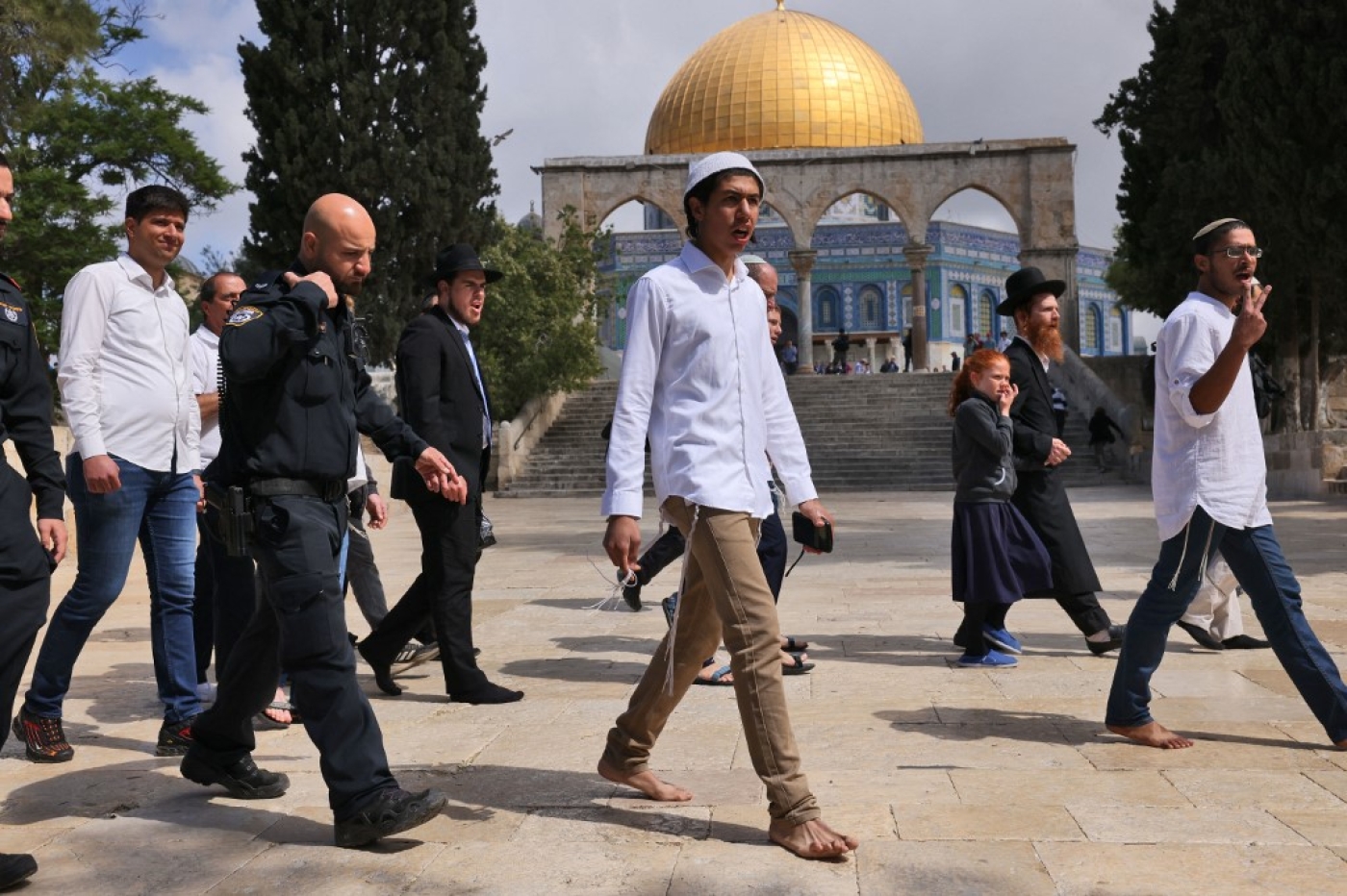 Israeli police accompany a group of Israeli far-right activists during a storming of al-Aqsa Mosque in the Old City of Jerusalem on 5 May 2022. (AFP)