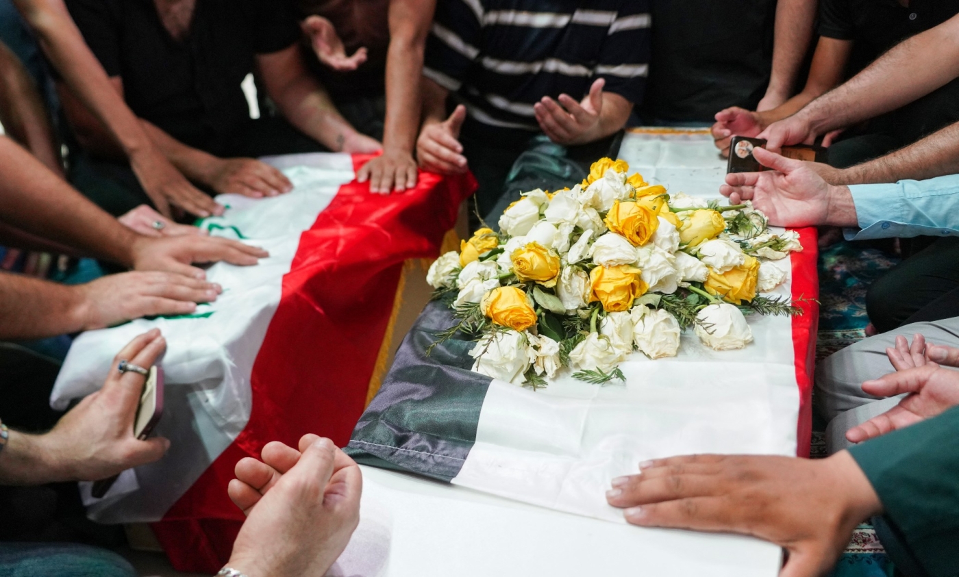 Iraqi mourners pray over the caskets of a woman and her niece killed in Zakho during their funeral in Najaf on 21 July 2022 (AFP)