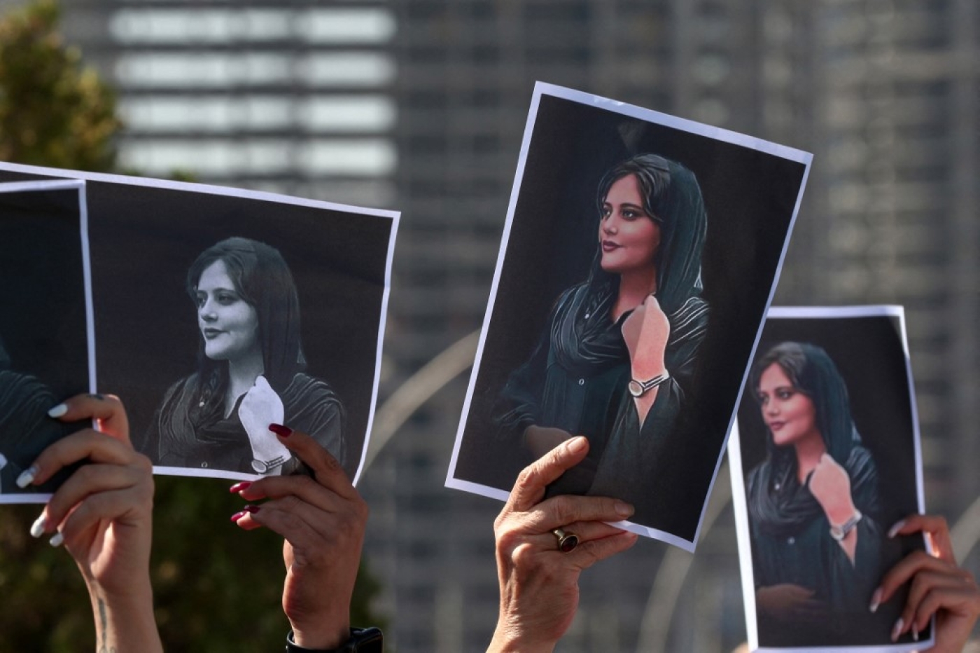 Des femmes brandissent des pancartes imprimées de la photo de Mahsa Amini, décédée à 22 ans alors qu’elle était détenue par les autorités iraniennes, lors d’une manifestation dénonçant sa mort devant les bureaux de l’ONU à Erbil, la capitale du Kurdistan autonome d’Irak, le 24 septembre 2022 (AFP/Safin Ahmed)