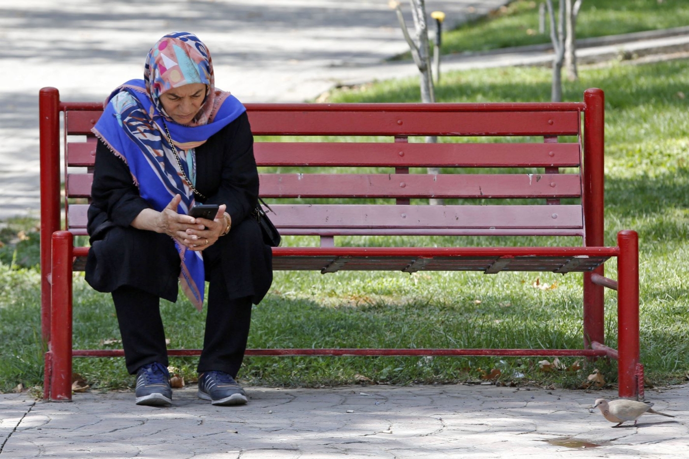 A woman sits at a park in Iran's capital Tehran, September 27, 2022 (AFP)