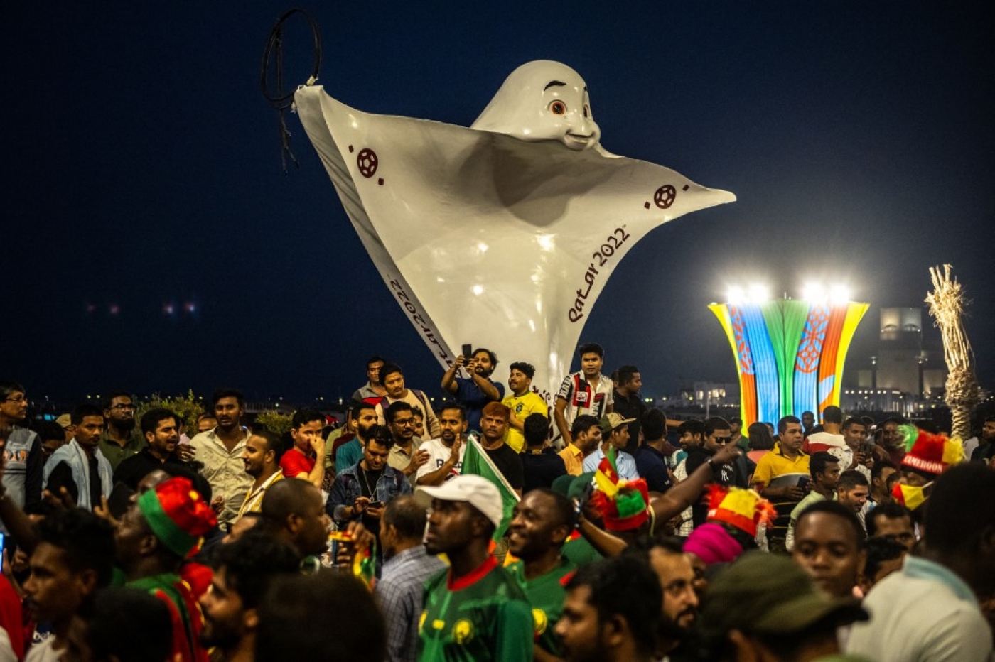 People gather in front of the offical mascot La'eeb at Corniche promenade in Doha on 18 November 2022, ahead of the Qatar 2022 World Cup football tournament (AFP)