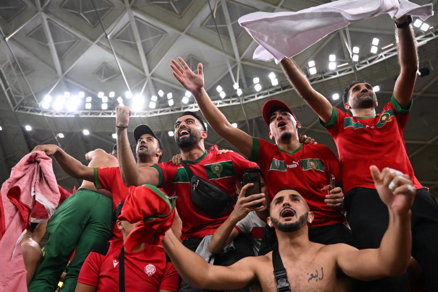 Les supporters marocains célèbrent la victoire avec leurs joueurs, au stade Al-Thumama de Doha, le 10 décembre 2022 (AFP/Kirill Kudryavtsev)