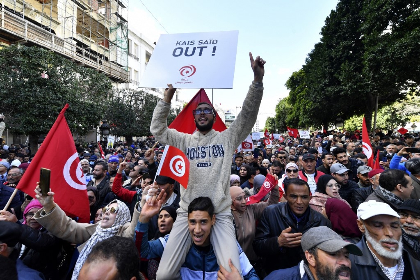 Des manifestants tunisiens brandissent des pancartes lors d’une manifestation dans le centre de Tunis contre leur président le 14 janvier 2023 (AFP/Fethi Belaid)