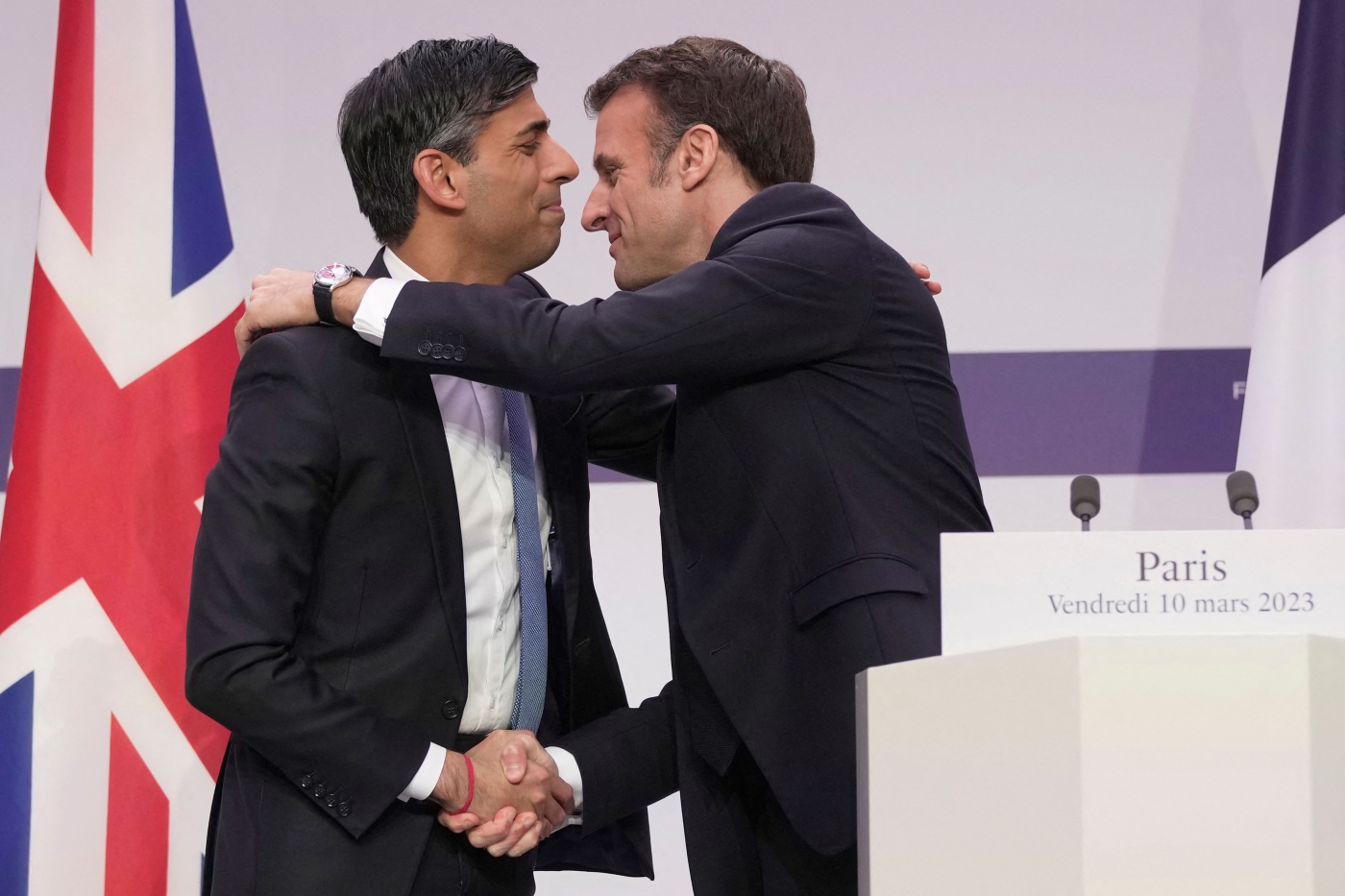 Britain's Prime Minister Rishi Sunak (L) and France's President Emmanuel Macron (R) attend shake hands during a joint press conference at the end of the French-British summit, at the Elysee Palace, in Paris, on March 10, 2023 (AFP)