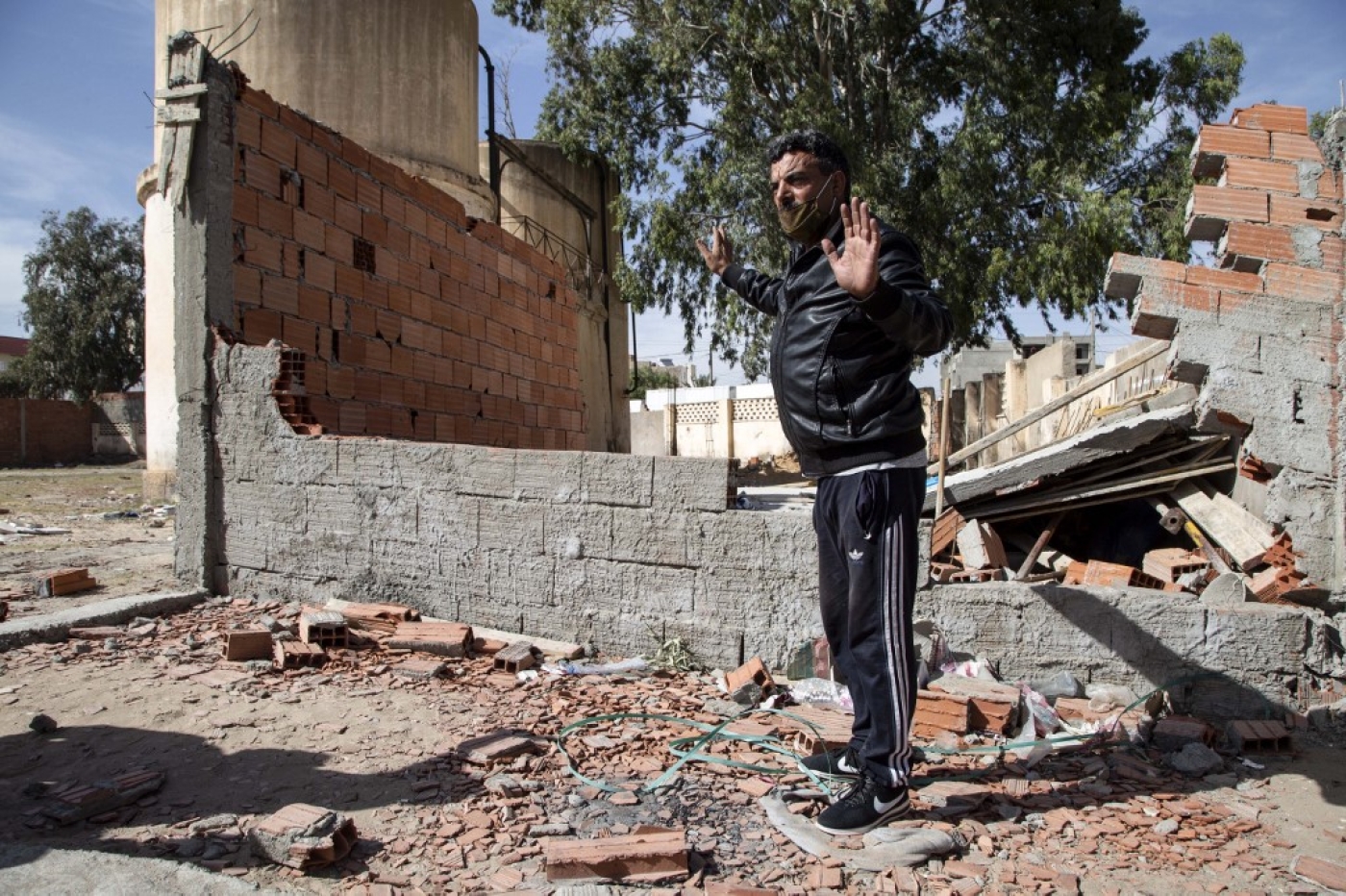 Un homme se tient sur les lieux où un Tunisien de 49 ans est mort lorsque les autorités ont démoli un kiosque illégal, un jour plus tôt, dans la ville de Sbeitla, dans la province de Kasserine, le 14 octobre 2020 (AFP)