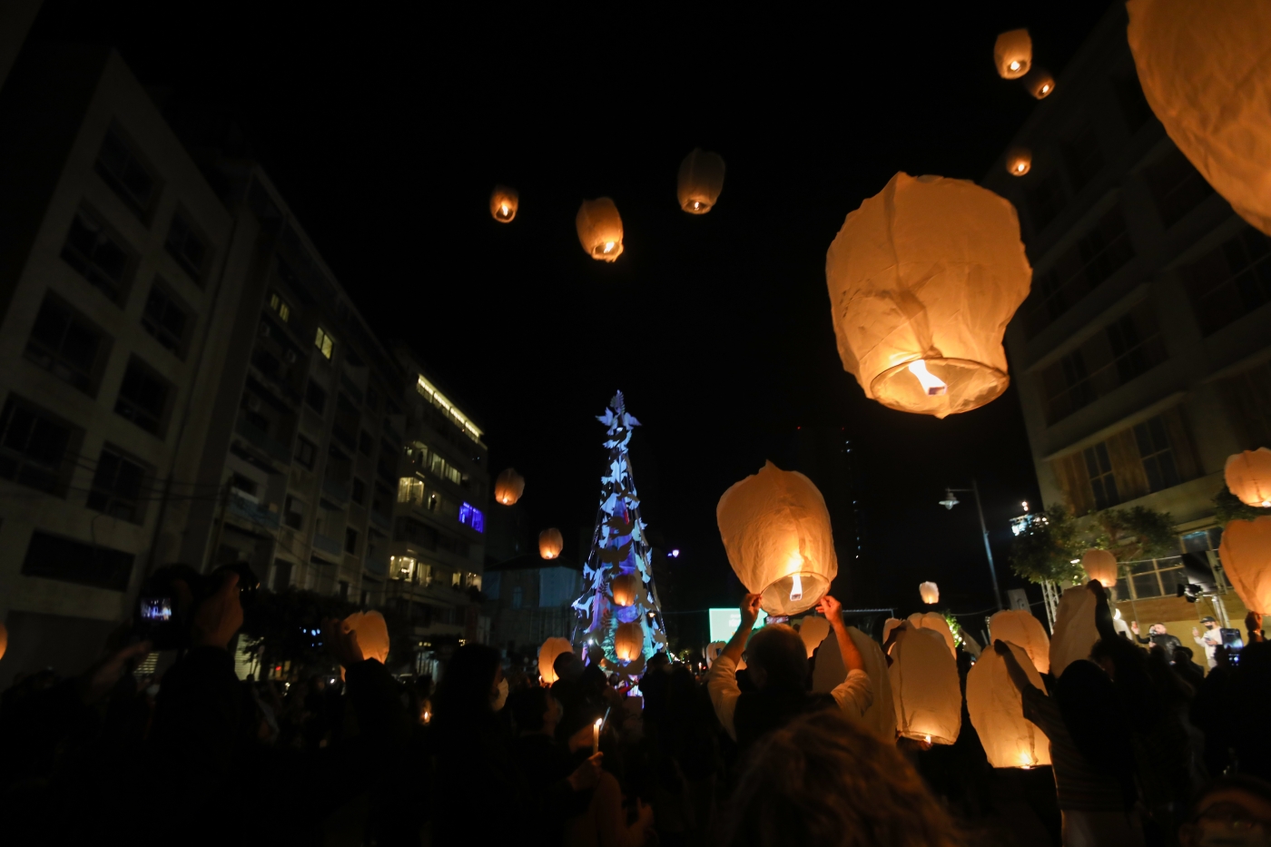 Des Libanais lancent des lanternes à la mémoire des victimes de l’explosion du port de Beyrouth, dans le quartier de Gemmayzé, à Beyrouth, le 20 décembre 2020 (AFP)