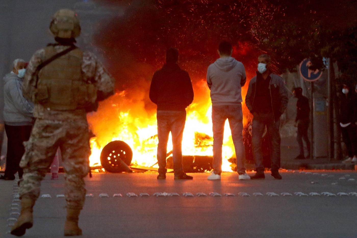 Des manifestants brûlent des pneus pour bloquer une route dans la ville de Saïda, dans le sud du Liban, le 8 mars 2021 (AFP)
