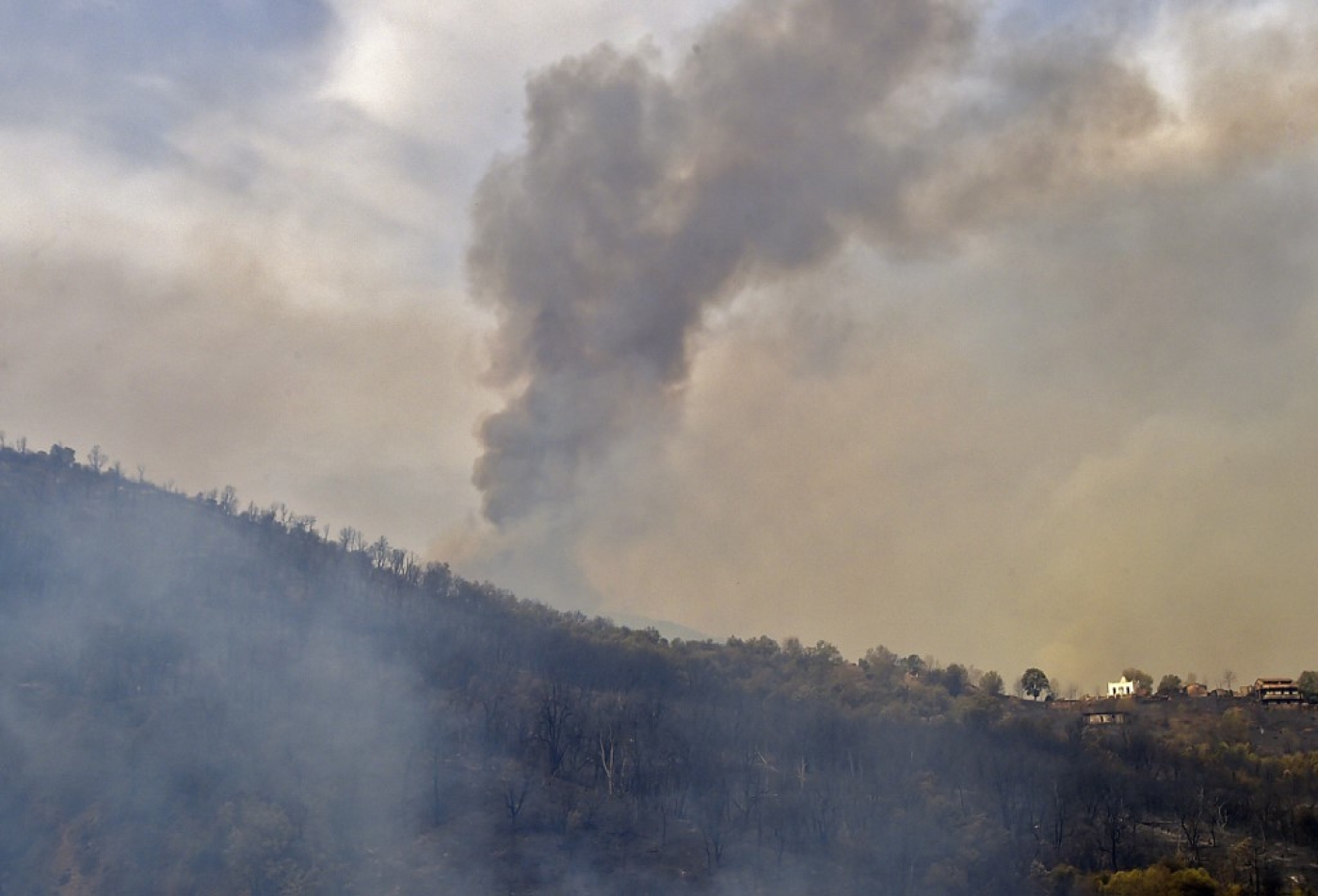 De la fumée s’échappe d’un incendie de forêt dans les collines boisées de la région de Kabylie, à l’est de la capitale Alger, le 10 août 2021 (AFP/Ryad Kramdi)