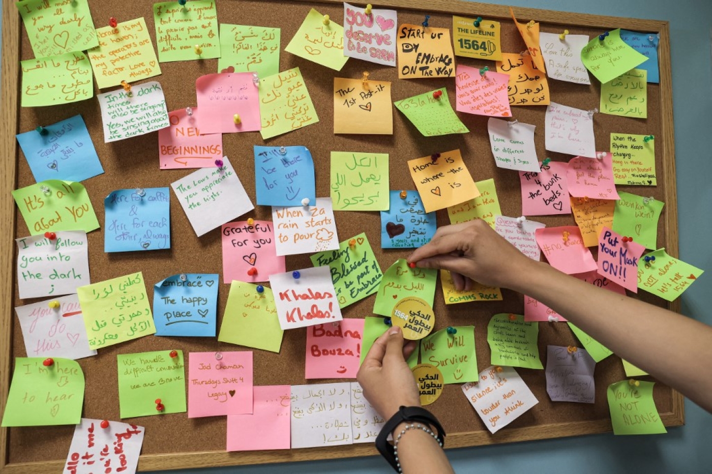 Une femme place une note sur un post-it dans les bureaux de l’ONG Embrace qui gère un numéro vert de prévention du suicide, à Beyrouth, le 1er septembre 2021 (AFP/Anwar Amro)