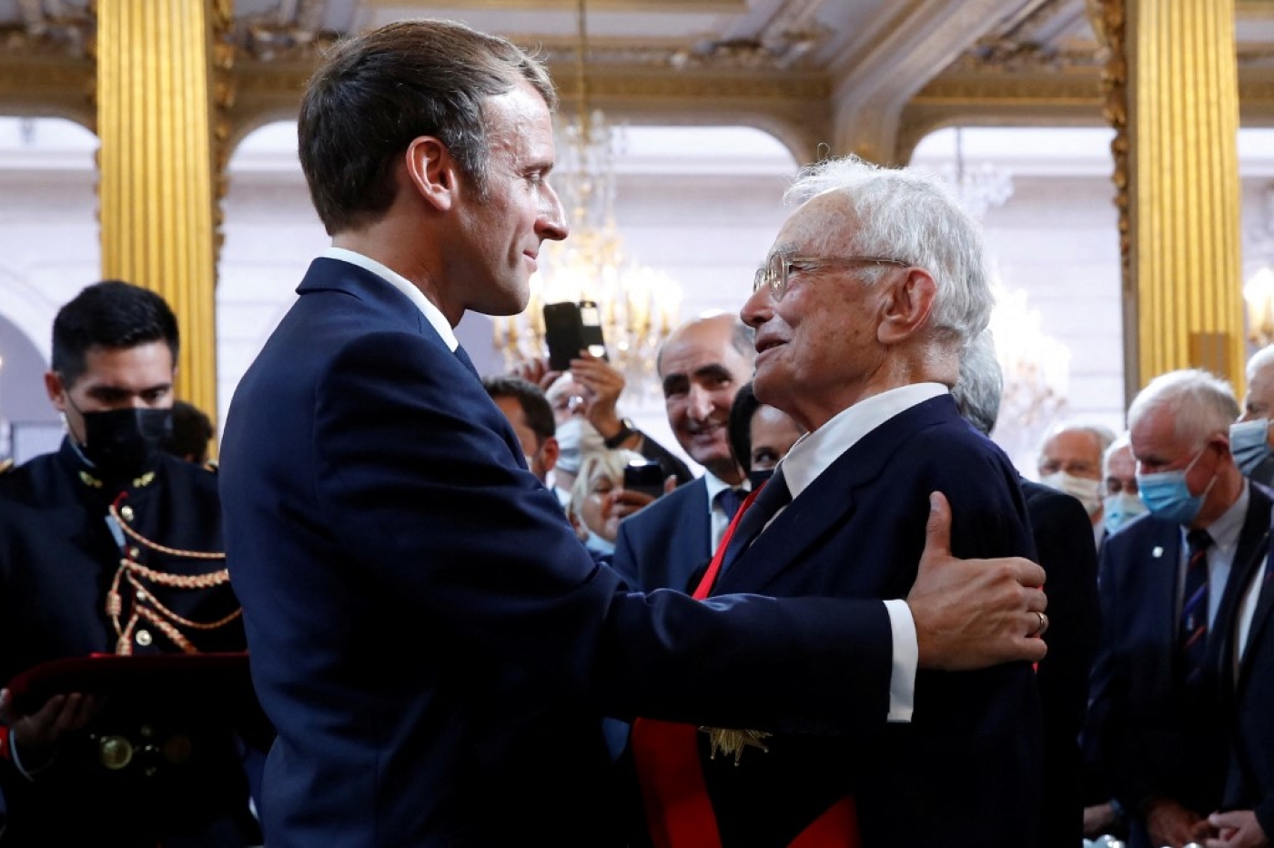 Le 20 septembre 2021 à l’Élysée, Emmanuel Macron décore le l’ancien général François Meyer, qui a organisé le rapatriement « de plusieurs centaines de harkis en désobéissant aux ordres » (AFP/Gonzalo Fuentes)