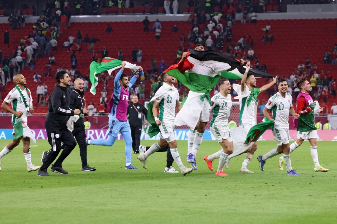  Les joueurs algériens arborent leur drapeau et celui de la Palestine après leur victoire face au Maroc à Doha, le 11 décembre 2021 (AFP / Karim Sahib)