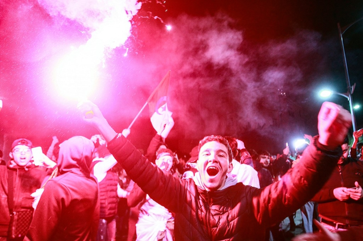 Des jeunes Algérois fêtent la victoire de leur équipe de football, finaliste de la Coupe arabe, à Alger, le 18 décembre 2021 (AFP)