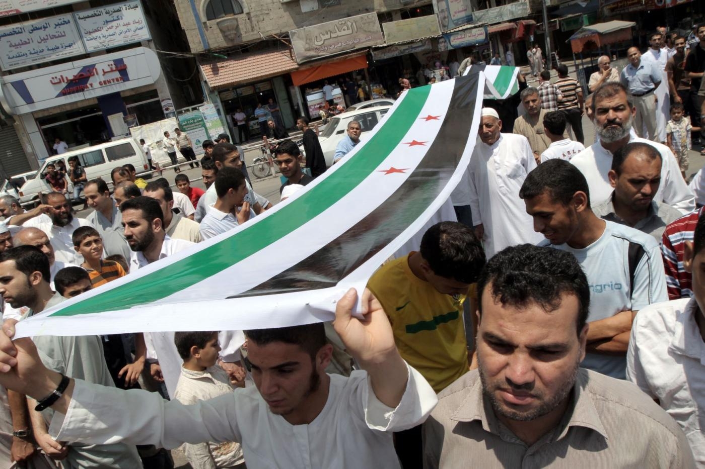 Des Palestiniens portant un drapeau de l’opposition syrienne manifestent contre le président syrien Bachar al-Assad et en soutien aux civils syriens dans le camp de réfugiés de Nuseirat (bande de Gaza), le 22 juin 2012 (AFP)