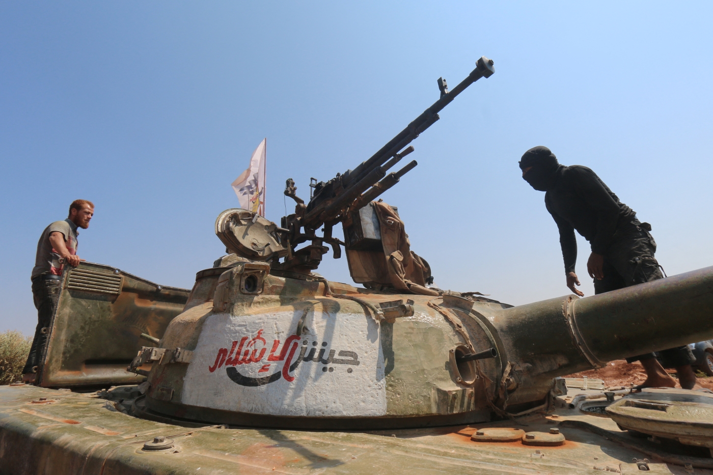 Rebel forces from Jaish al-Islam (Army of Islam) stand on a tank as they hold a position on August 24, 2015 near the frontline in the al-Zahra area, on the northwestern outskirts of Aleppo (AFP)
