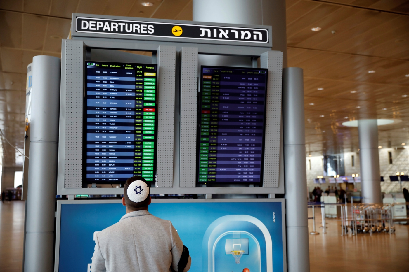 Un homme consulte un panneau d’information sur les vols dans le terminal des départs de l’aéroport international Ben Gourion de Lod, près de Tel-Aviv (Israël), le 10 mars 2020 (Reuters)