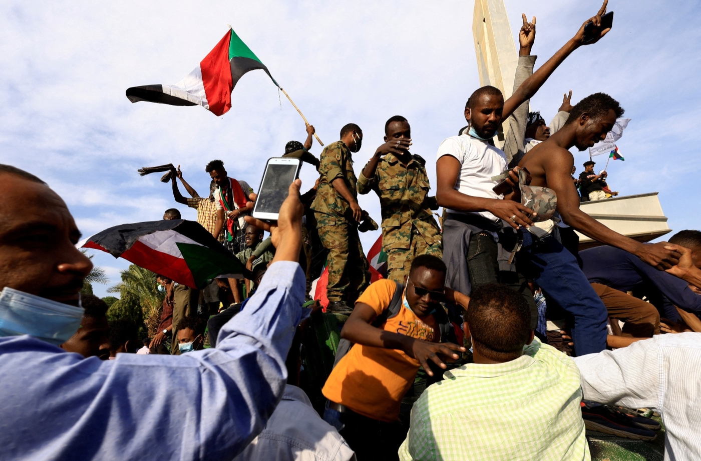 Des manifestants contre le régime militaire montent sur le toit d’un véhicule militaire pour célébrer leur arrivée au palais présidentiel, le 19 décembre à Khartoum (Reuters)