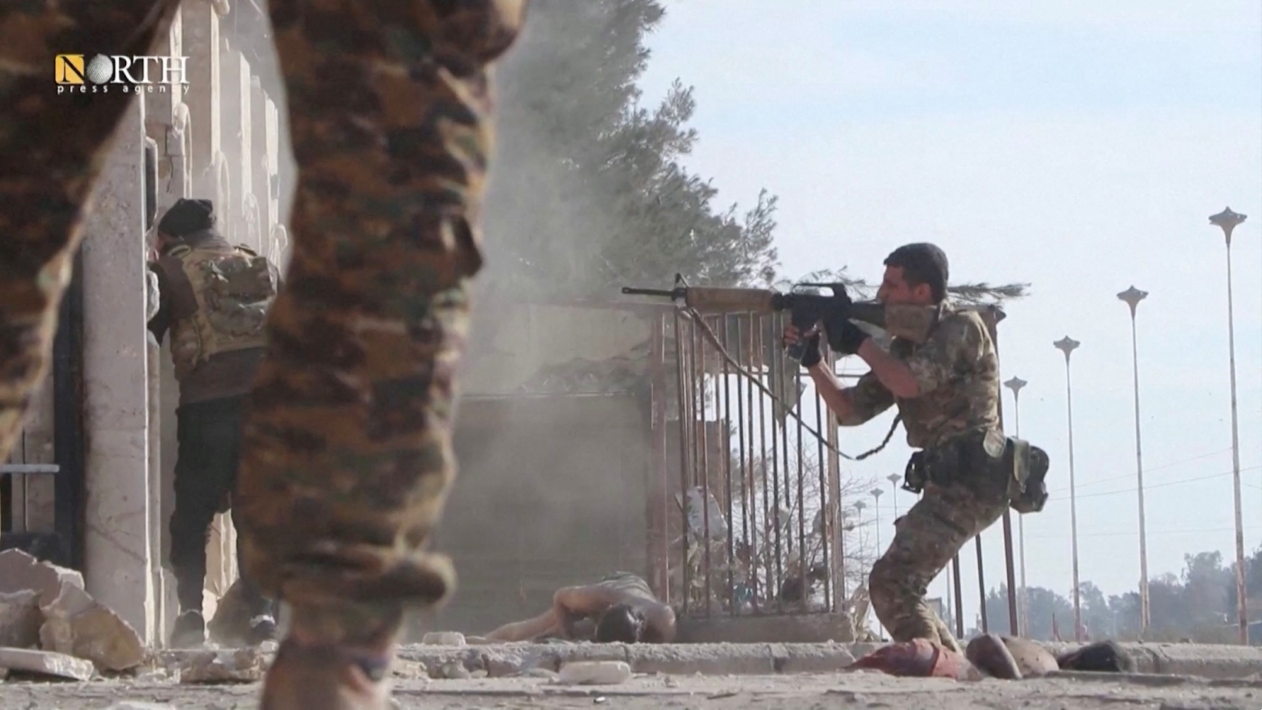 Un membre des Forces démocratiques syriennes braque son arme à l’extérieur d’une prison au cours d’affrontements avec des combattants de l’État islamique à Hassaké (Reuters)