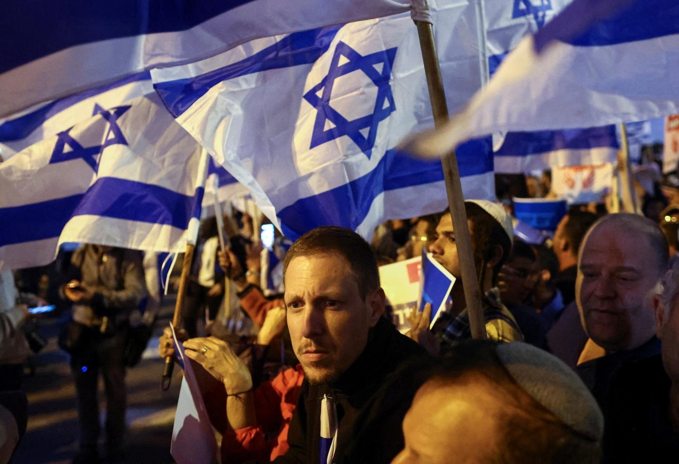 Des activistes israéliens brandissent des drapeaux nationaux lors d’un rassemblement de droite à Jérusalem, le 6 avril 2022 (Reuters)