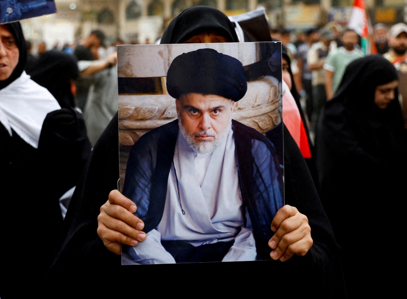 A supporter of Muqtada al-Sadr holds his picture during a celebration after Iraq's parliament passed a law criminalising normalisation of relations with Israel (Reuters)