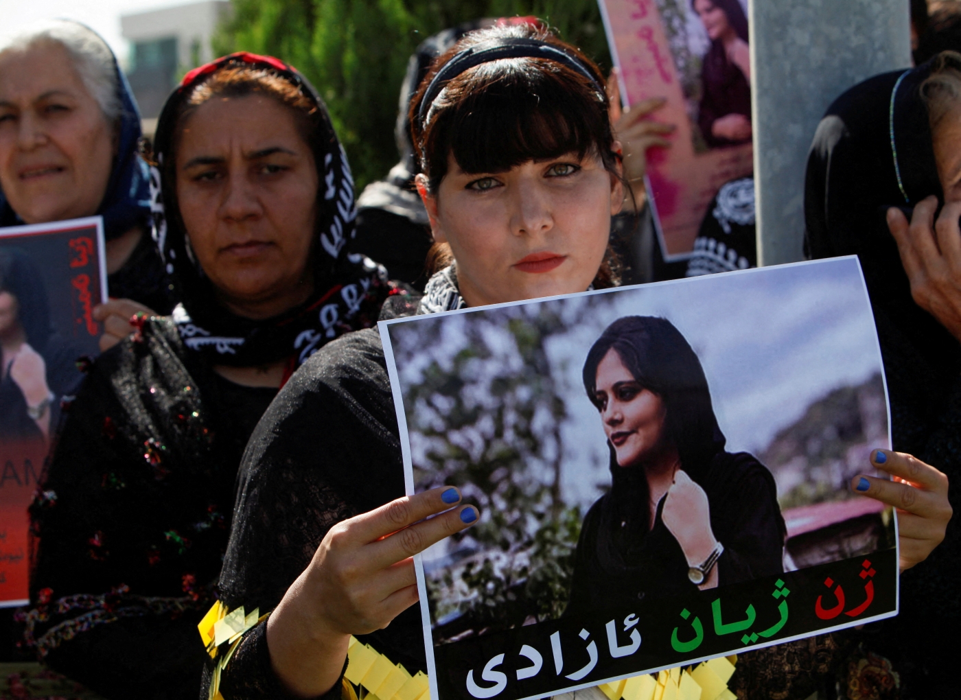 A woman holds a placard during a protest following the death of Mahsa Amini in front of the United Nations headquarters in Erbil, Iraq on 24 September 2022 (Reuters)