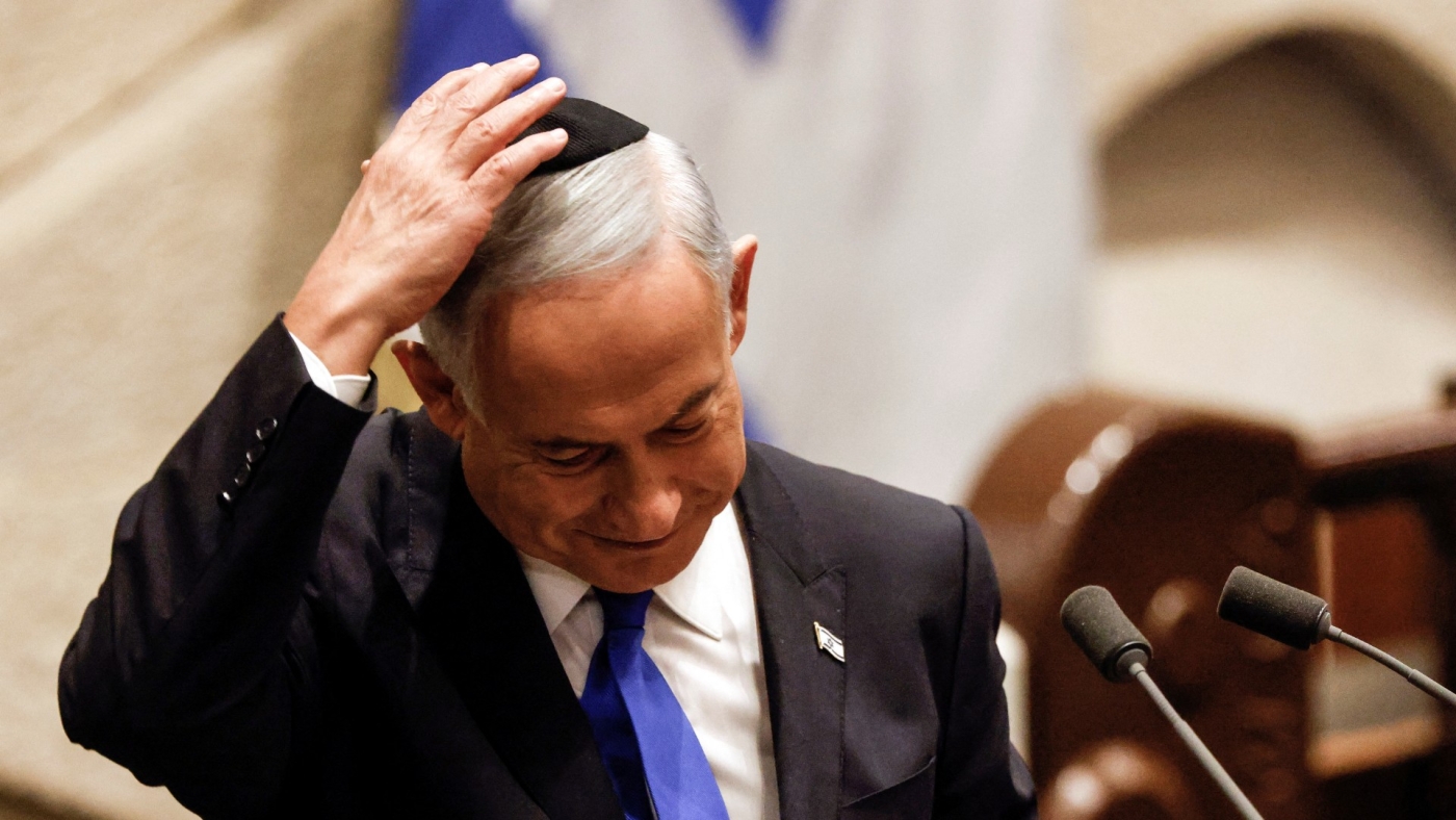 Benjamin Netanyahu adjusts his kippah after speaking at a special session of the Knesset to approve and swear in a new government, in Jerusalem 29 December (Reuters)