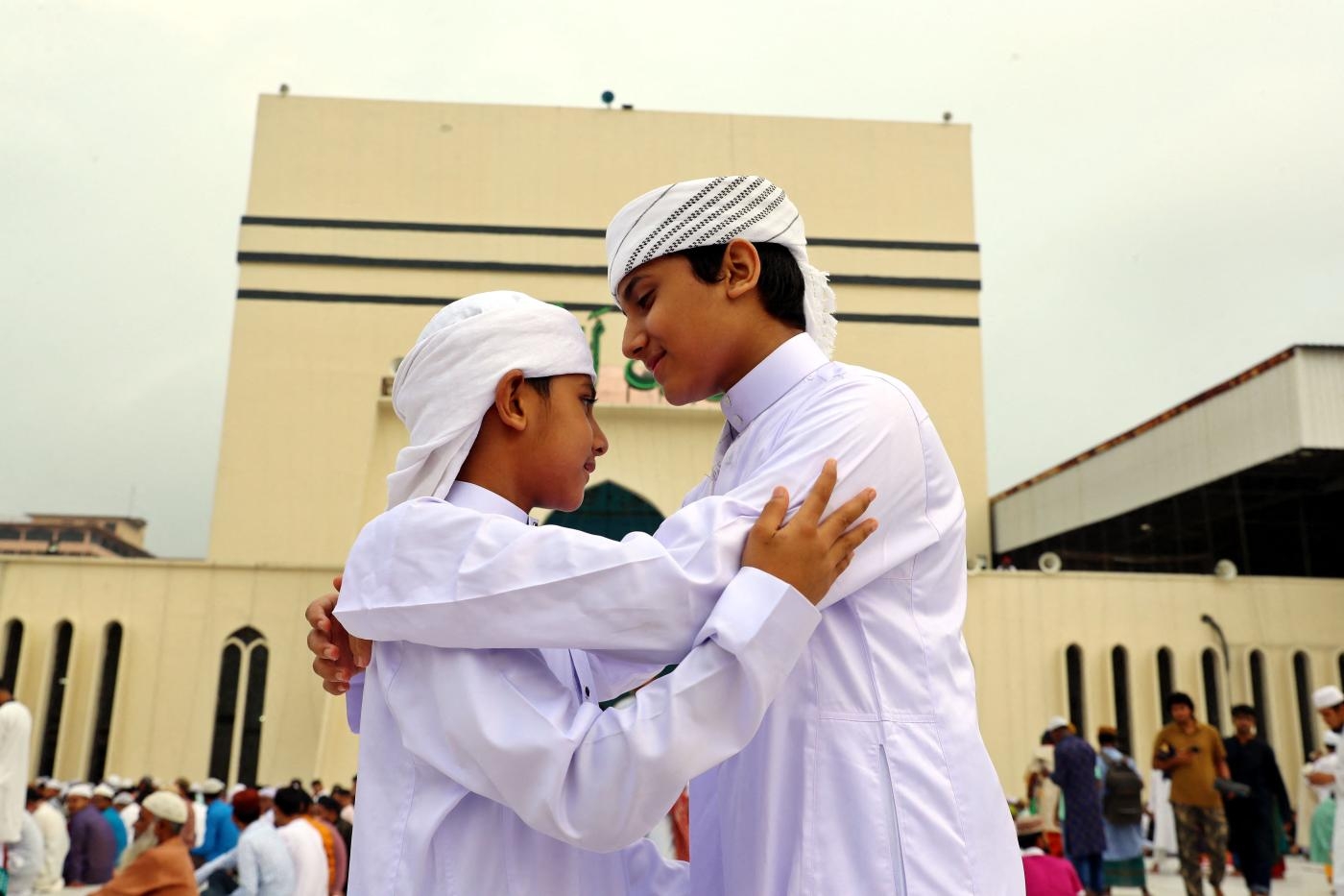 Deux jeunes musulmans se saluent devant leur mosquée au Bangladesh (Reuters)