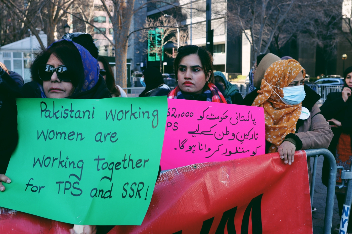 Women hold signs in front of the UN on 9 March demanding protection status for undocumented Pakistanis in the US.