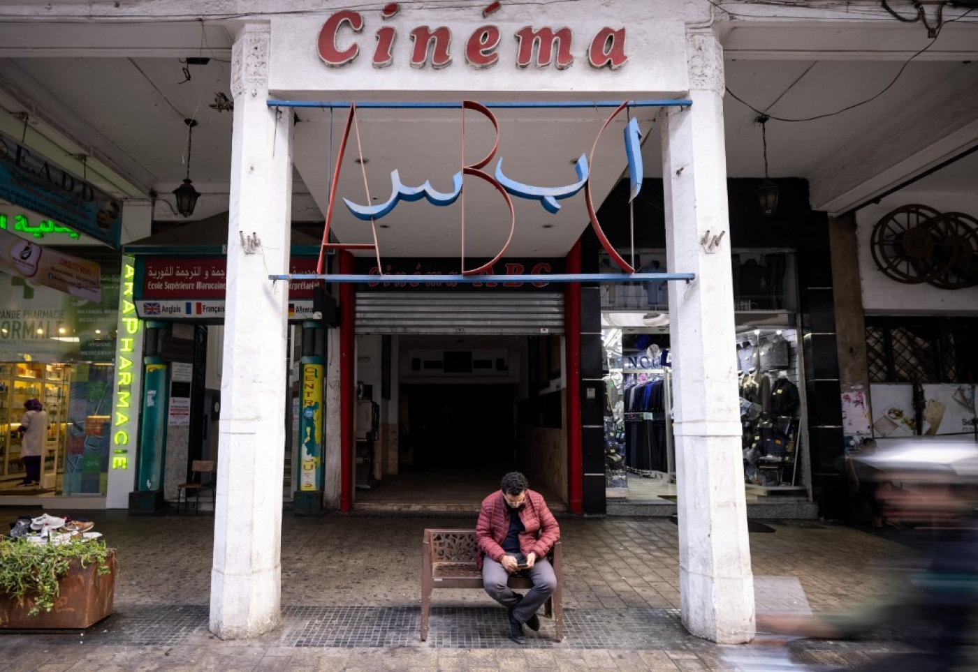 A man sits at the entrance of the ABC cinema, in the western Moroccan city of Casablanca, 24 January 2022 (AFP)