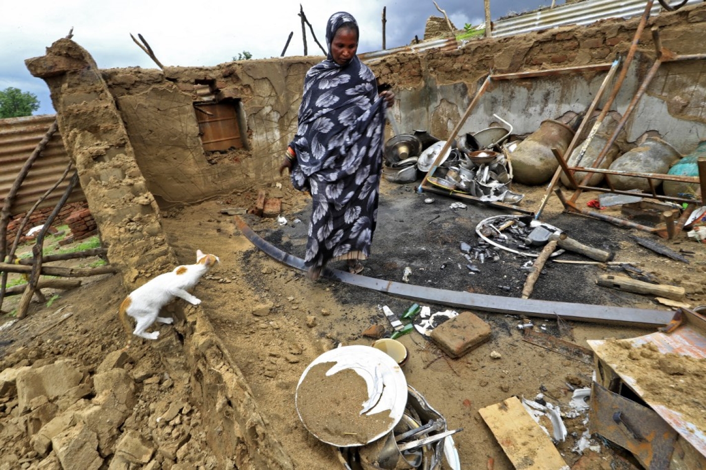 A woman surveys the damage to her house after tribal clashes in al-Roseires, in Sudan's Blue Nile state, earlier this year, 8 August 2022 (AFP)