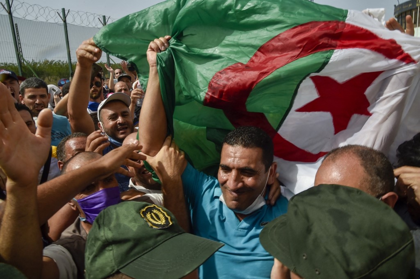 Karim Tabbou, l’une des figures les plus connues du hirak, est salué à sa sortie de prison le 2 juillet 2020, près de la ville de Tipasa, à 70 km à l’ouest de la capitale Alger (AFP/Ryad Kramdi)