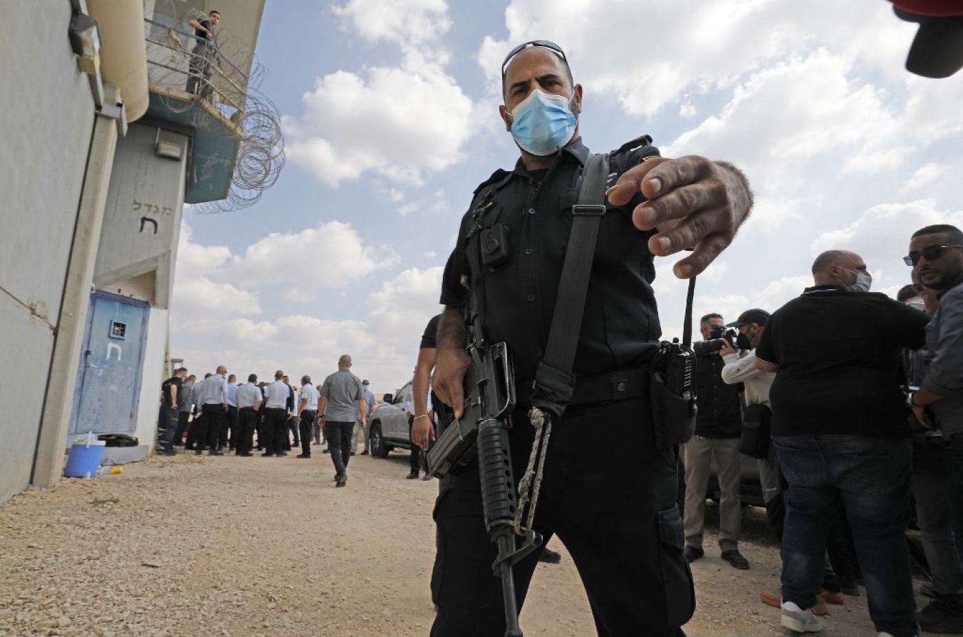 Un officier israélien tend le bras devant la prison de Gilboa, dans le nord d’Israël, le 6 septembre 2021 (AFP)
