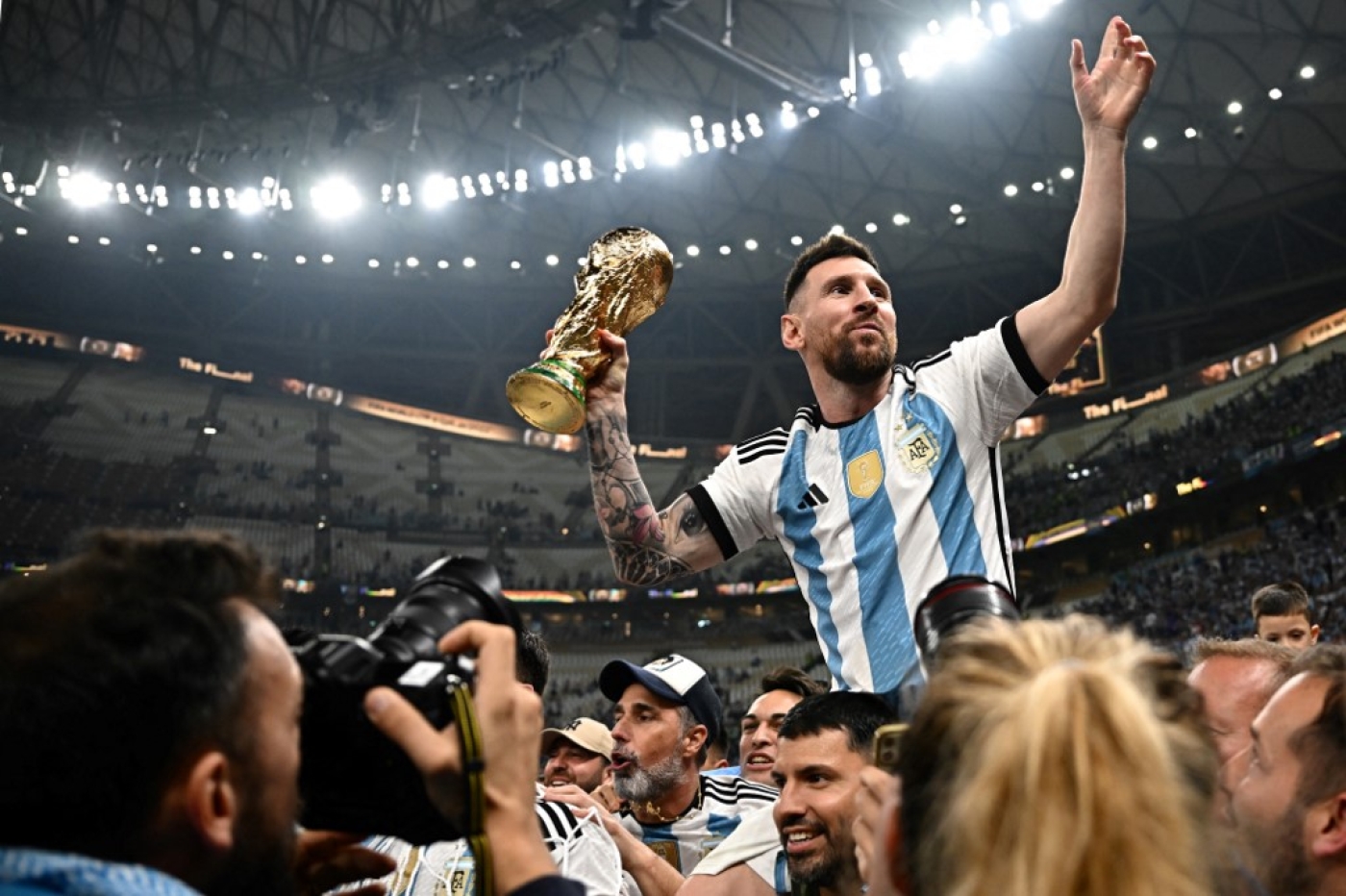 Argentina's captain Lionel Messi (R) holds the Fifa 2022 World Cup after Argentina beat France on penalties in the final at Qatar's Lusail Stadium to be crowned world champions (AFP)