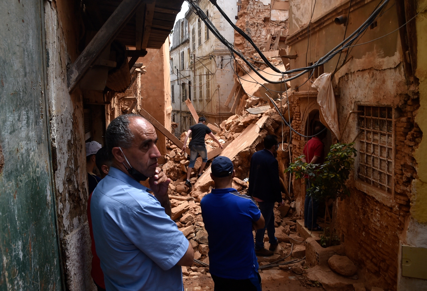Des habitants de la Casbah regardent un immeuble qui s’est effondré, le 6 juin 2020 (AFP/Ryad Kramdi)