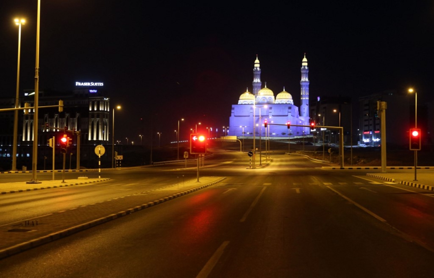 An empty road is pictured with the Bahwan Mosque in the Omani capital, Muscat
