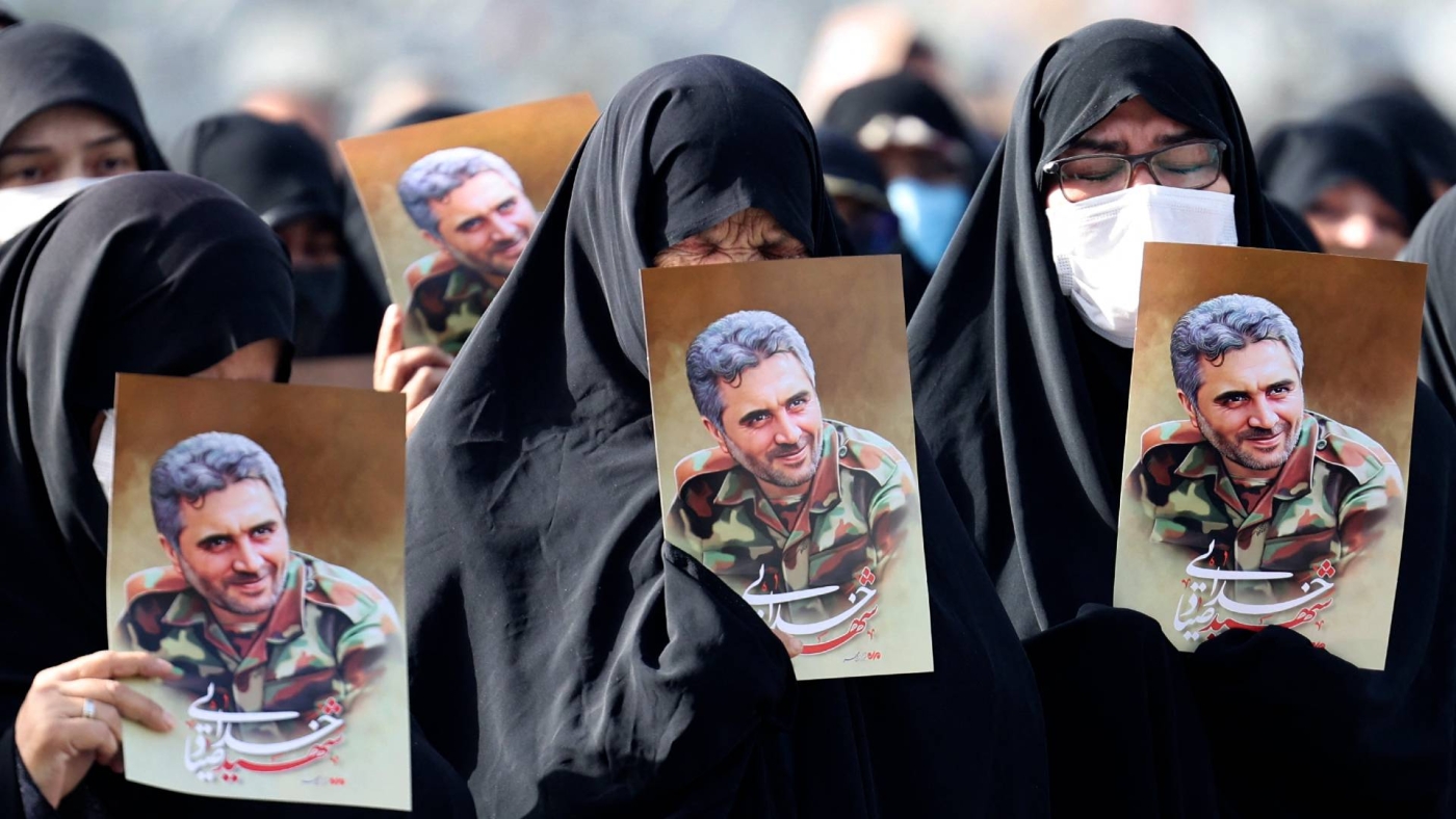 Iranian women lift portraits of Revolutionary Guards colonel Sayyad Khodai during his funeral procession at Imam Hussein square in the capital Tehran, 24 May 2022 (AFP)